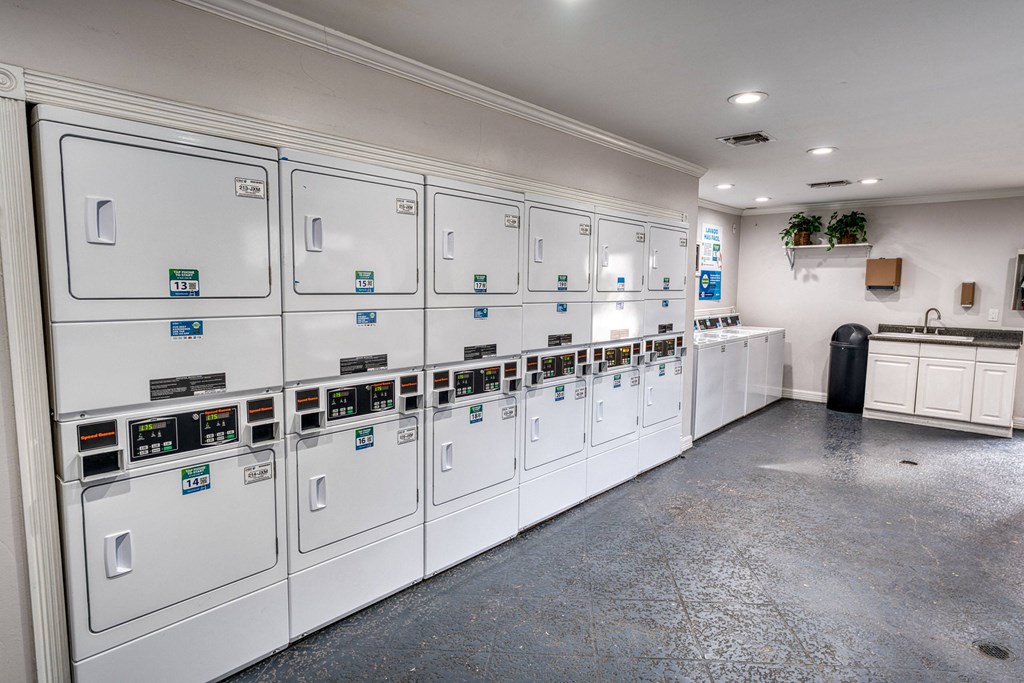 a utility room with many white utility machines in it at Juniper Springs Apartments, Austin, TX